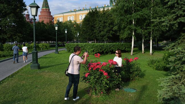 Молодой человек фотографирует девушку в Александровском саду в Москве