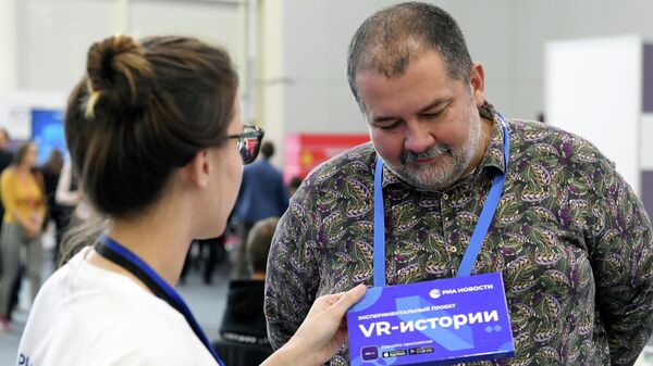Писатель Сергей Лукьяненко на стенде МИА Россия сегодня во время III Всемирного цифрового саммита по интернету вещей и искусственному интеллекту в Казани
 