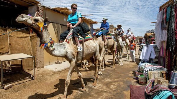 Туристы на верблюдах в деревне Гарб-Сахель в районе Асуана в Египте