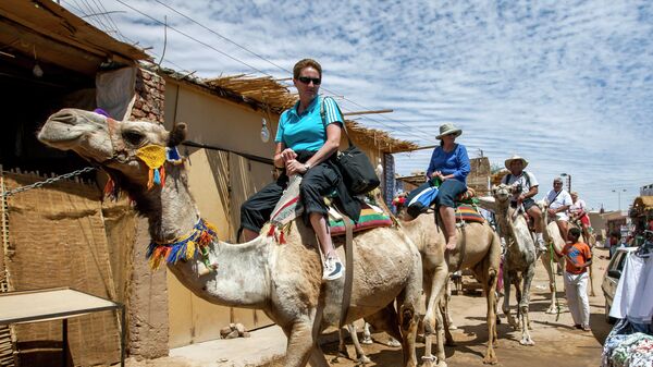 Туристы на верблюдах в деревне Гарб-Сахель в районе Асуана в Египте