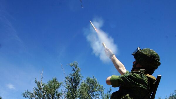 Военнослужащий ЛНР запускает сигнальную ракету белого цвета