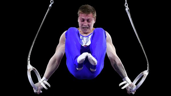 Денис Аблязин (Россия) выполняет упражнения на кольцах в командном многоборье среди мужчин на чемпионате мира по спортивной гимнастике в Штутгарте.