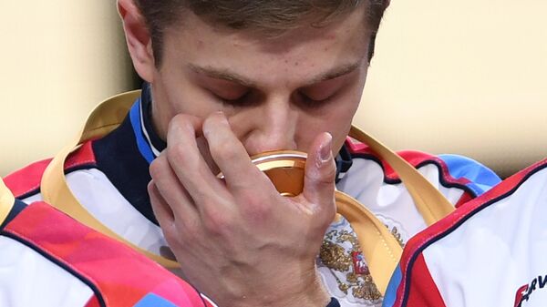 Иван Стретович (Россия), завоевавший золотую медаль в командном многоборье среди мужчин, на церемонии награждения на чемпионате мира по спортивной гимнастике в Штутгарте.