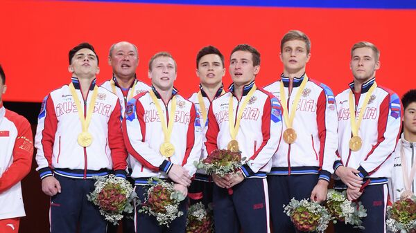Спортсмены сборной России, завоевавшие золотые медали в командном многоборье среди мужчин, на церемонии награждения на чемпионате мира по спортивной гимнастике в Штутгарте.