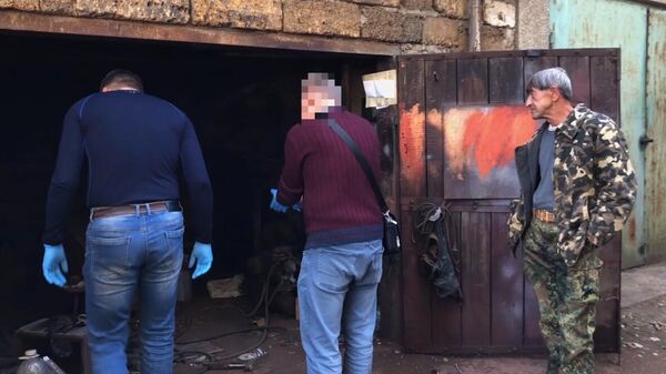Сотрудники ФСБ проводят обыск в гараже у задержанного гражданина России, готовившего взрыв в одном из административных зданий Республики Крым