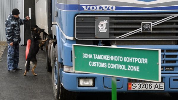 Сотрудник таможенной службы РФ с собакой осуществляет досмотр автомобиля на контрольно-пропускном пункте Бугристое российско-казахстанской границы Сотрудник таможенной службы РФ с собакой осуществляет досмотр автомобиля на контрольно-пропускном пункте Бугристое российско-казахстанской границы