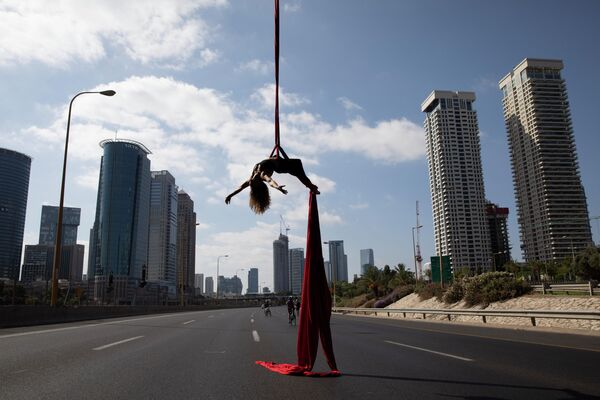 Израильская акробатка Tel Karassin выступает на пустой автомобильной трассе во время празднования Йом-Киппура в Тель-Авиве 