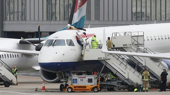 Протестующий Джеймс Браун лежит на самолете British Airways в аэропорту Лондон-Сити