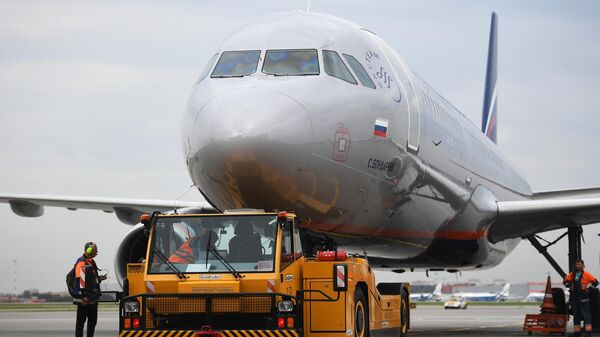 Аэродромный тягач и самолет авиакомпании Аэрофлот Airbus A321 в аэропорту Шереметьево