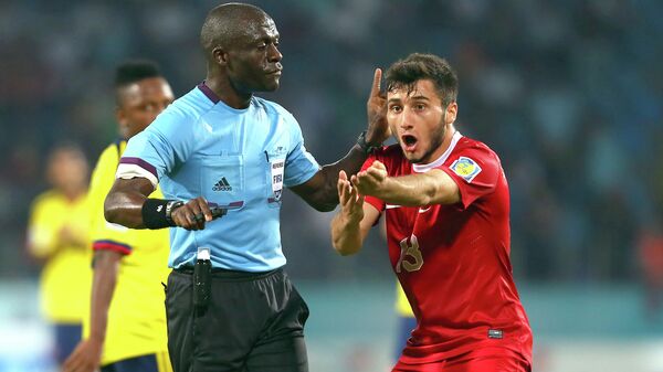 Футболист молодежной сборной Турции Дженк Шахин спорит с судьей