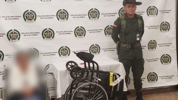 Представители Колумбийской  полиции и задержанная в аэропорту города Рионегро женщина, перевозившая в своей инвалидной коляске 17 килограммов кокаина
