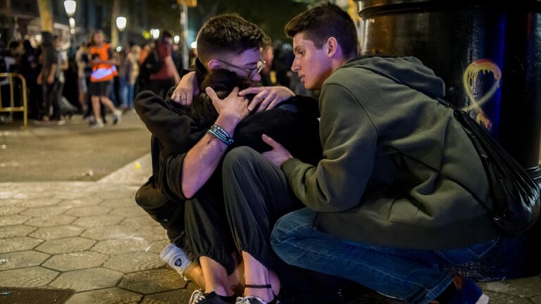 Участники акции протеста помогают пострадавшему на одной из улиц Барселоны. 15 октября 2019