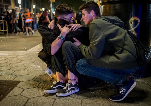 Участники акции протеста помогают пострадавшему на одной из улиц Барселоны. 15 октября 2019