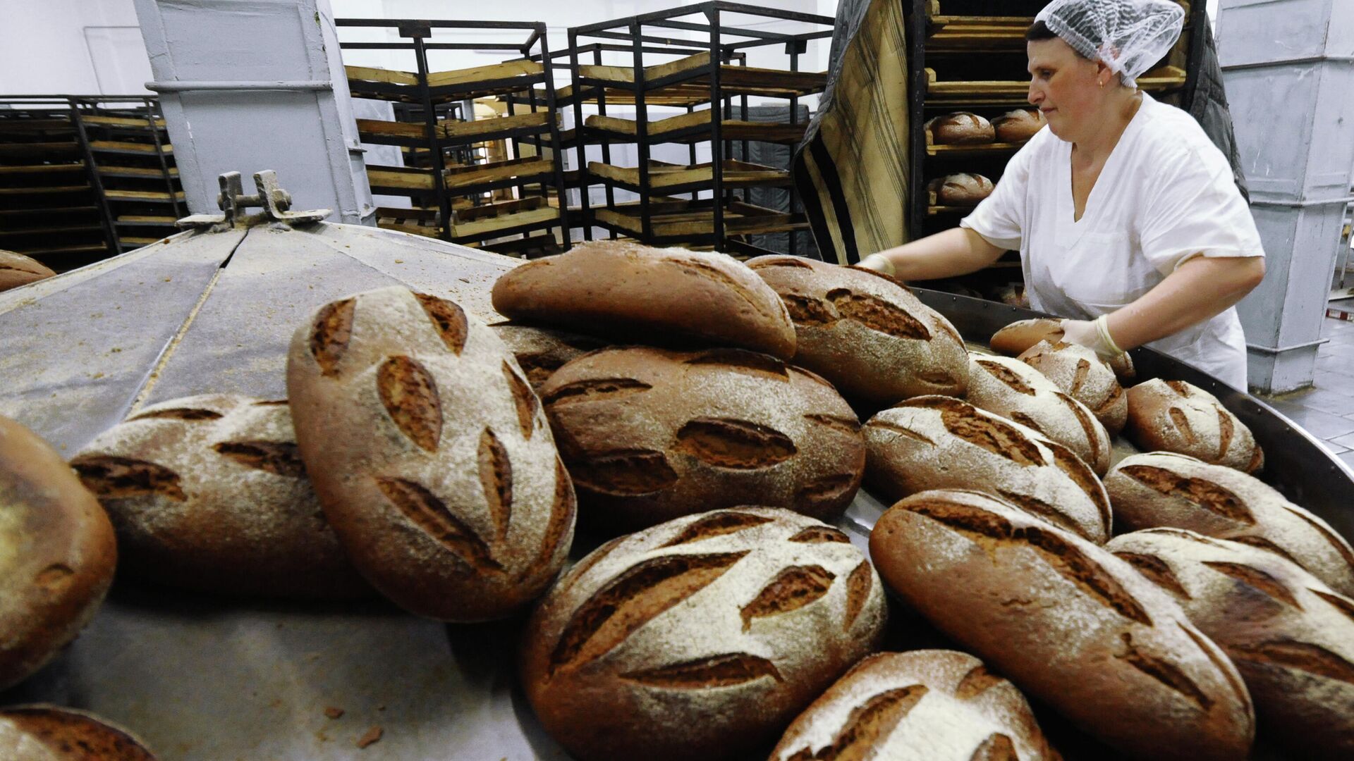 Укладчик хлеба  выкладывает хлеб на лотки - РИА Новости, 1920, 23.09.2020