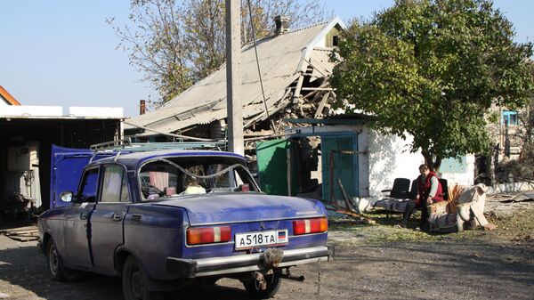Поврежденный автомобиль у жилого дома в поселке Старомихайловка города Донецка после обстрела
