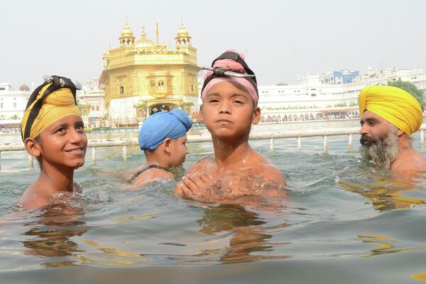 Люди празднуют годовщину рождения четвертого сикхского Гуру Рам Даса в Золотом храме