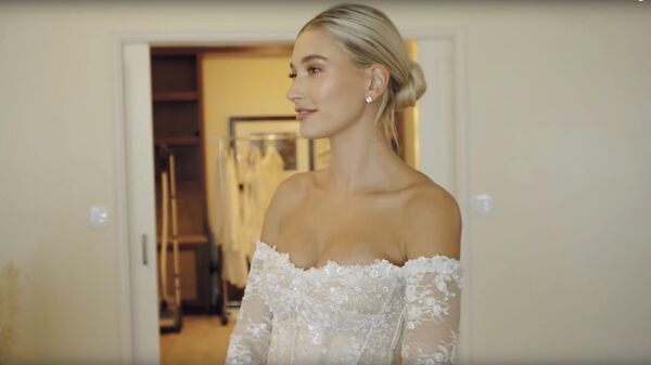 Стоп-кадр видео примерки свадебного платья американской моделью Хейли Род Бибер