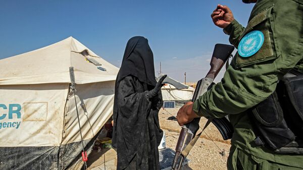 Курдский охранник в лагере для иностранных боевиков и их семей в Сирии