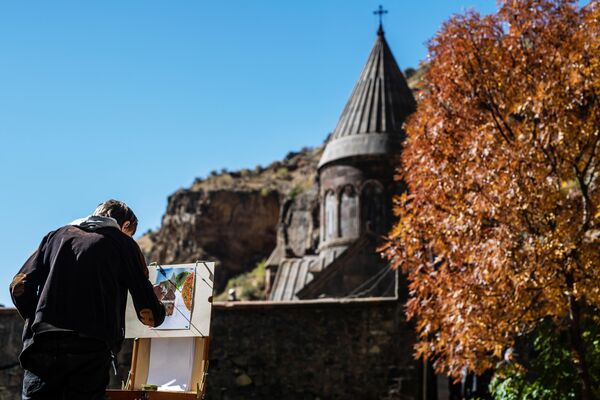 Молодой человек рисует монастырь Гегард в Котайкской области Армении