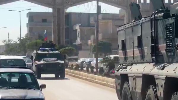 Колонна российских военных полицейских в сирийском городе Кобани на границе с Турцией. Стоп-кадр видео