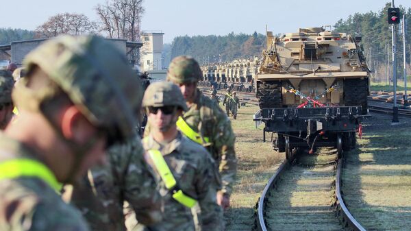Военнослужащие первой дивизии армии США во время переброски бронетехники на железнодорожной станции в Литве