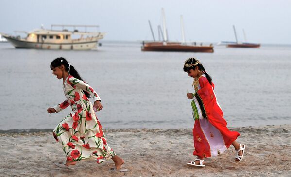 Девочки бегают по берегу острова Далма, ОАЭ 