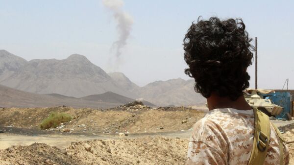 Повстанец в провинции Мариб смотрит на дым поднимающийся от взрыва