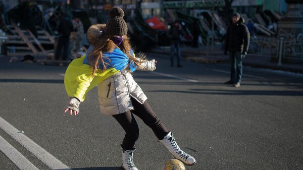 Девушка играет с мячом на улице Крещатик в Киеве