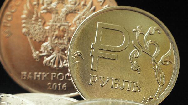 Монета номиналом один рубль с символикой Российского рубля. На заднем плане - герб Российской Федерации на монете номиналом пять рублей РФ