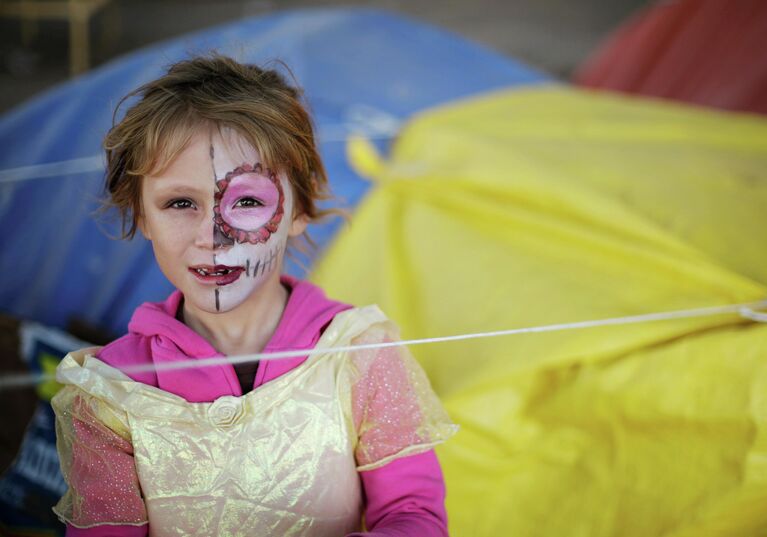 Девочка в гриме на Хэллоуин в лагере для беженцев в Сьюдад-Хуарес, Мексика