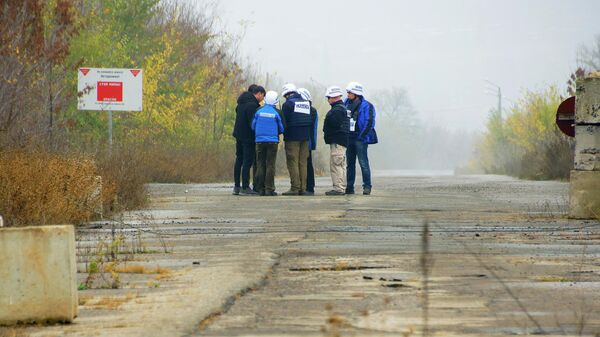 Наблюдатели ОБСЕ в поселке Золотое в Луганской области, где происходит отвод сил бойцов подразделений ЛНР