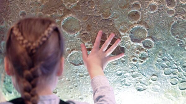 Юная посетительница у глобуса Луны в музее Урании Московского планетария