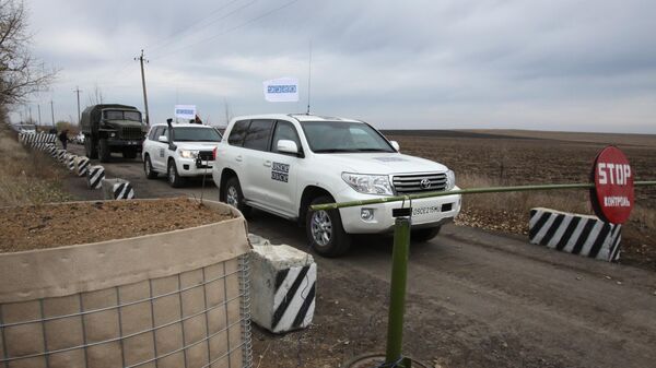 Автомобили специальной мониторинговой миссии ОБСЕ в селе Петровское в Донецкой области, где должен состояться отвод сил бойцов подразделений  ДНР