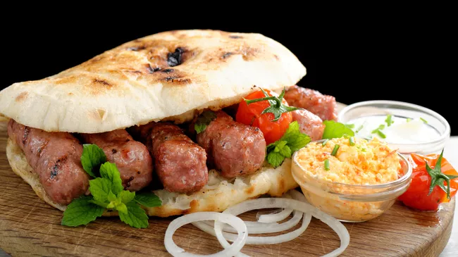 Чевапчичи на гриле с маринованным красным перцем и творожным сыром каймак Чевапчичи на гриле с маринованным красным перцем и творожным сыром каймак