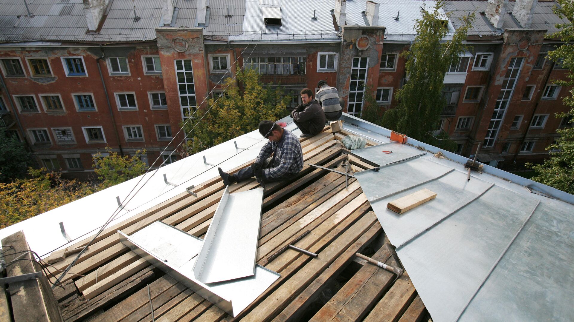 Рабочие перекрывают крышу многоэтажного дома - РИА Новости, 1920, 01.04.2021