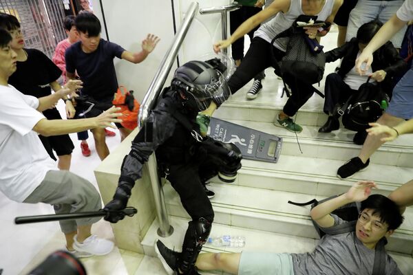 Столкновения протестующих с полицией в торговом центре Гонконга Столкновения протестующих с полицией в торговом центре Гонконга