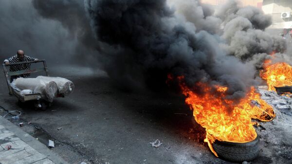 Демонстранты жгут покрышки во время акция протеста в Багдаде, Ирак