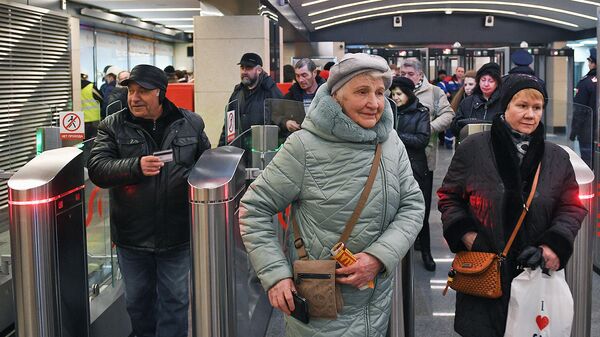 Пассажиры проходят через турникеты Московского метрополитена