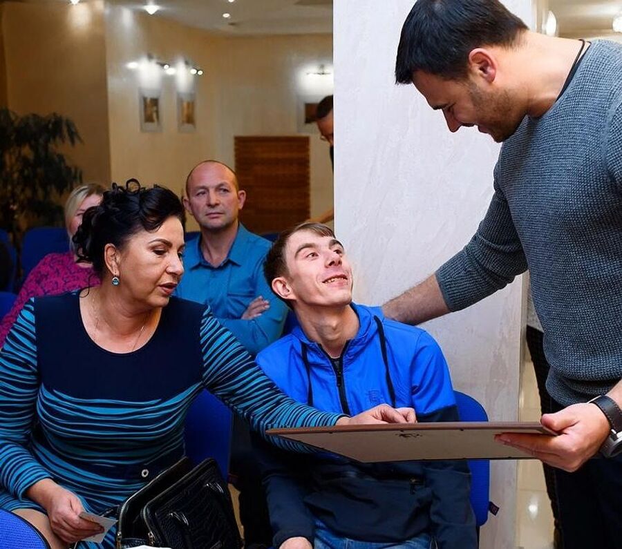Влад дарит свою картину певцу Эмину Агаларову, который помог оплатить ему один из курсов реабилитации за границей