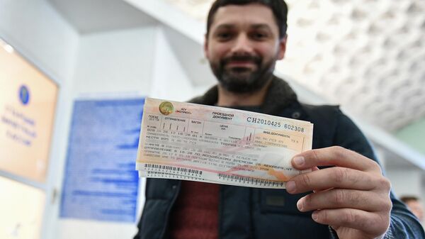 Мужчина демонстрирует купленный билет на железнодорожном вокзале в Симферополе
