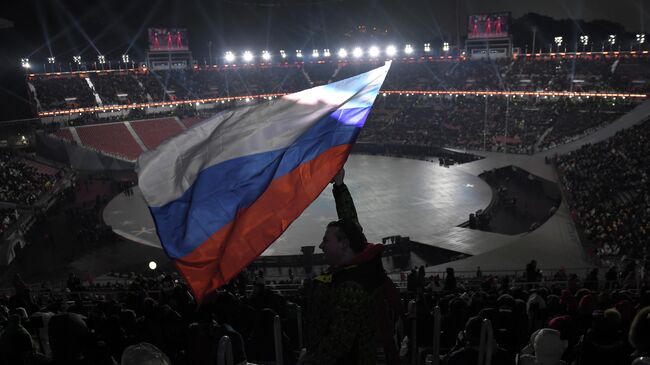 A spectator waves the Russian flag ahead of the opening ceremony of the Pyeongchang 2018 Winter Olympic Games at the Pyeongchang Stadium on February 9, 2018. (Photo by LOIC VENANCE / AFP)