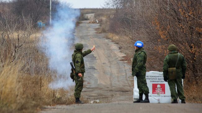 Представитель самопровозглашенной Донецкой народной республики запускает сигнальную ракету как сигнал о готовности вывода подразделений Народной милиции ДНР из участка возле села Петровское