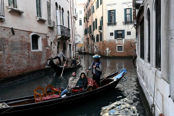Гондолы с туристами на канале в Венеции