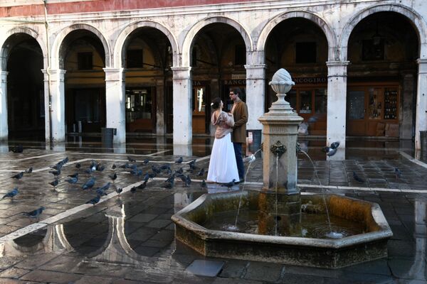 Молодые люди у фонтана на одной из улиц в Венеции