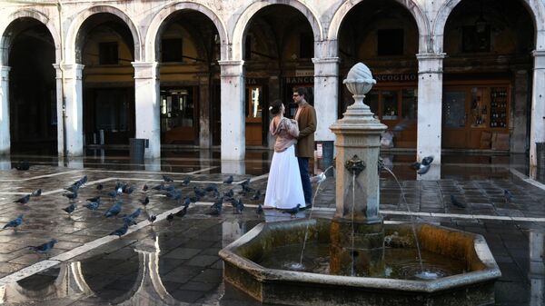 Молодые люди у фонтана на одной из улиц в Венеции
