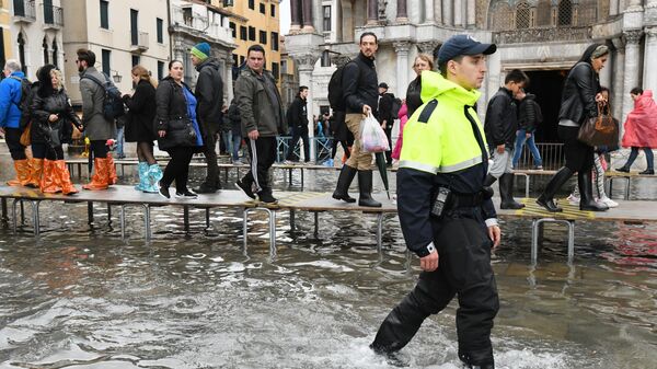 Туристы на площади Сан-Марко в Венеции во время наводнения