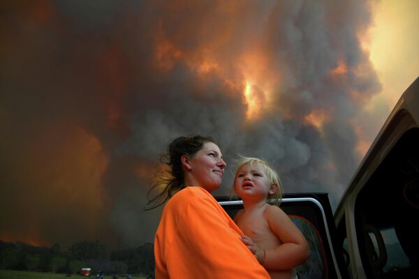 Женщина с дочерью смотрят на дым от лесных пожаров, Австралия, 12 ноября 2019 года