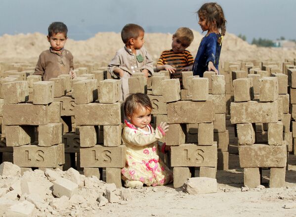 Афганские дети играют на кирпичном заводе на окраине Джелалабада