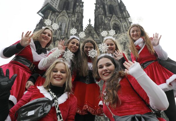 Девушки в новогодних костюмах позируют перед Кельнским собором