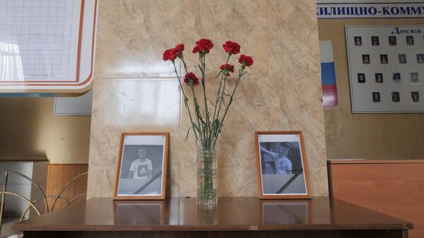 Цветы у портретов погибших молодых людей в холле Амурского колледжа строительства и жилищно-коммунального хозяйства в Благовещенске, где произошла стрельба